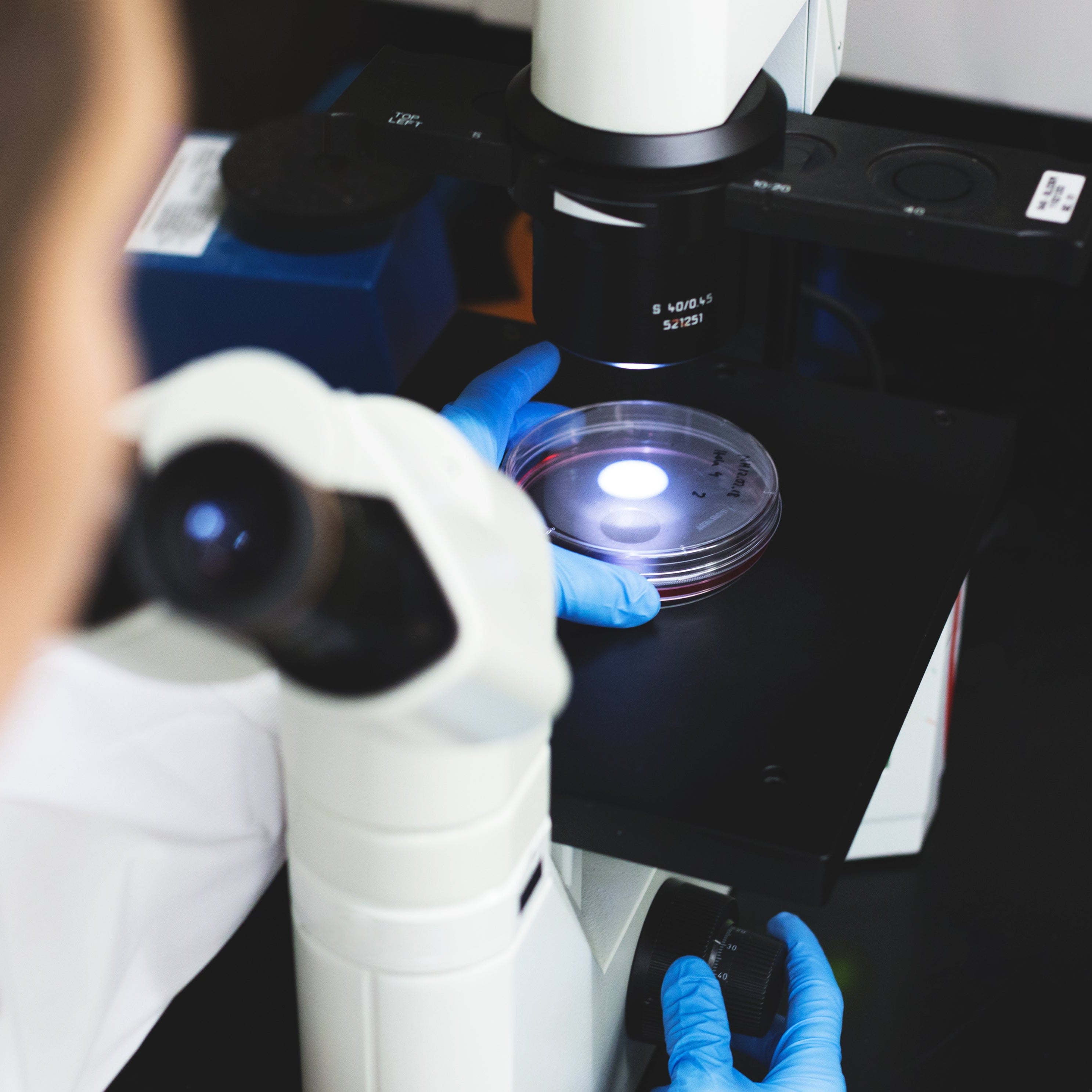 Person using a microscope in a laboratory setting